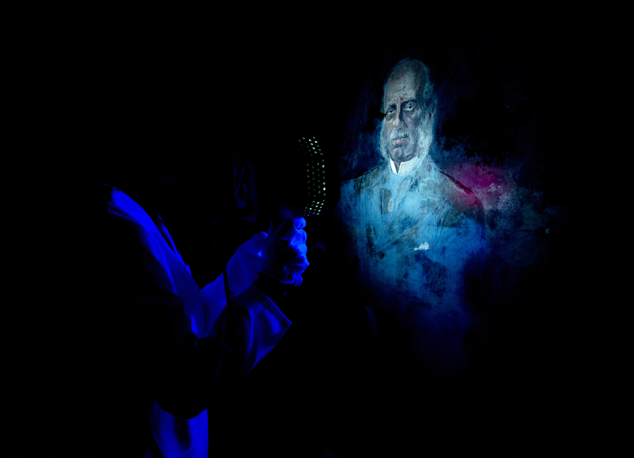Sandra Mottaz, specialist in conservation and analytic restoration, analyzes a painting with ultraviolet light, searching for signs of forgery, on September 19, 2014 at the Fine Arts Experts Institute (FAEI), in Geneva. AFP PHOTO / RICHARD JUILLIART (Photo credit should read Richard Juilliart/AFP/Getty Images)