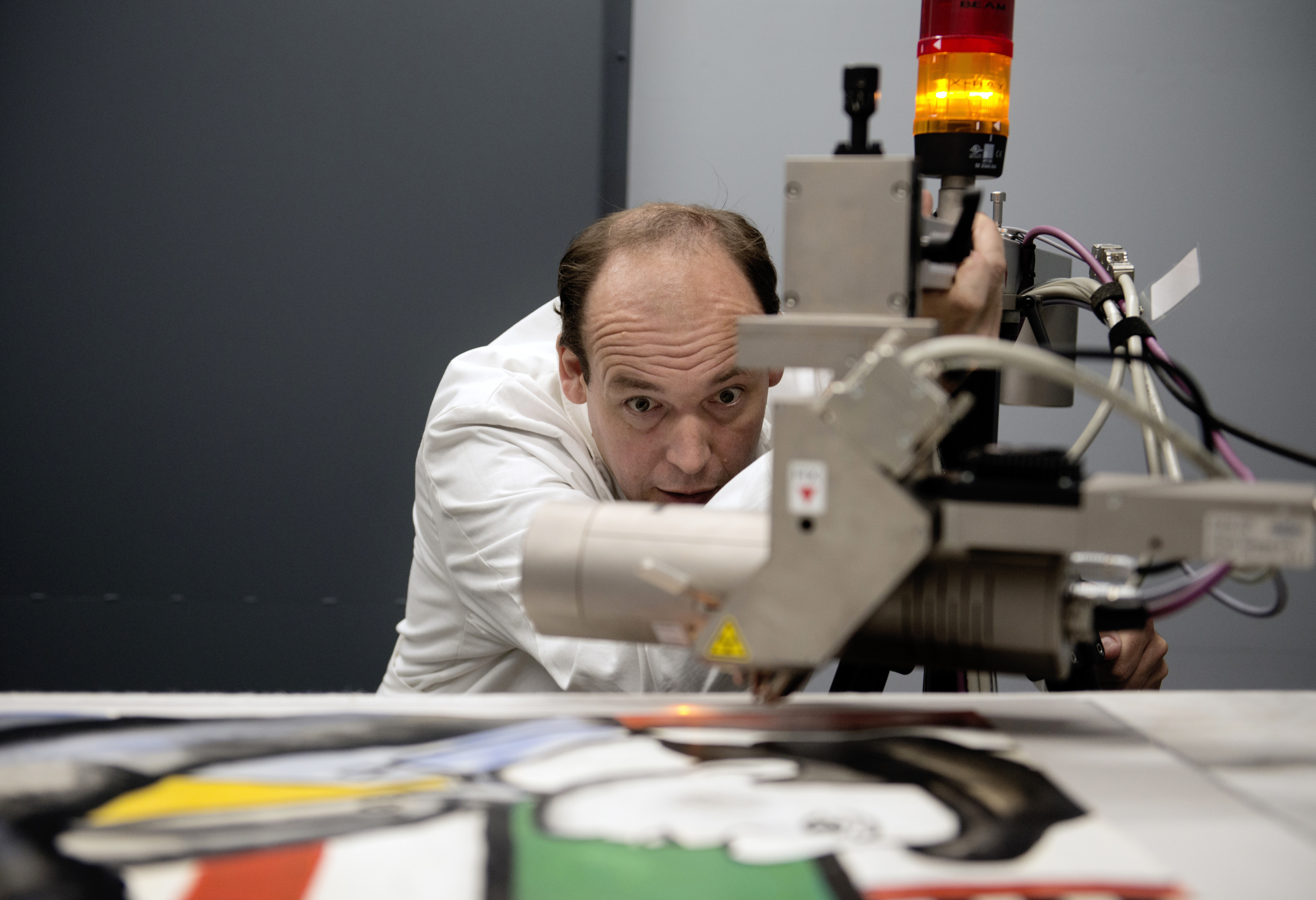 Dr. Killian Anheuser, head scientist at the Fine Arts Experts Institute (FAEI), analyses a bold-coloured painting purportedly by French master Fernand Leger, searching for signs of forgery, on September 19, 2014 in Geneva. AFP PHOTO / RICHARD JUILLIART (Photo credit should read Richard Juilliart/AFP/Getty Images)
