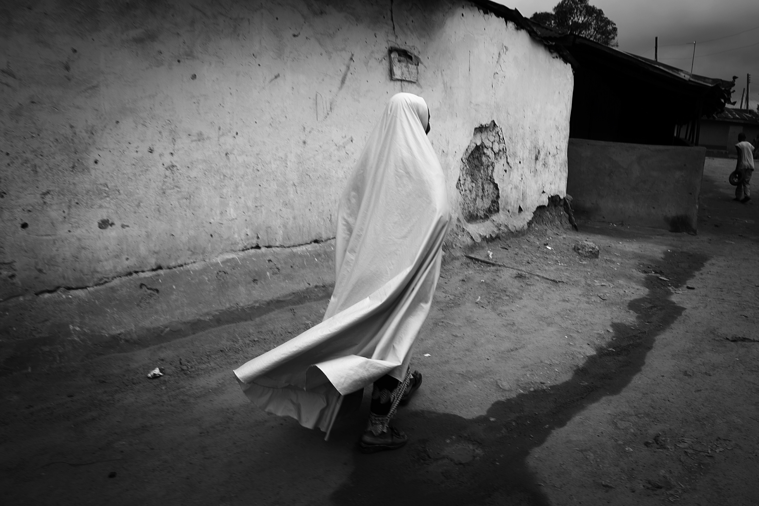 NIGERIA,Kaduna.
A woman walks in a street of a Muslim district of kaduna. In the city of Kaduna every community lives in its district. It is rare to find places or Muslim and Christian live together.
Nearly 4,000 people have died in Nigeria due to the violent conflict over the past decade.
The economic and ethnic conflict in the northern states has a religious dimension. It is only with true governance that these conflicting differences could be managed. As elsewhere in Nigeria, residents accuse both local and state government officials for promoting identity-based divisions to advance their own political agendas.