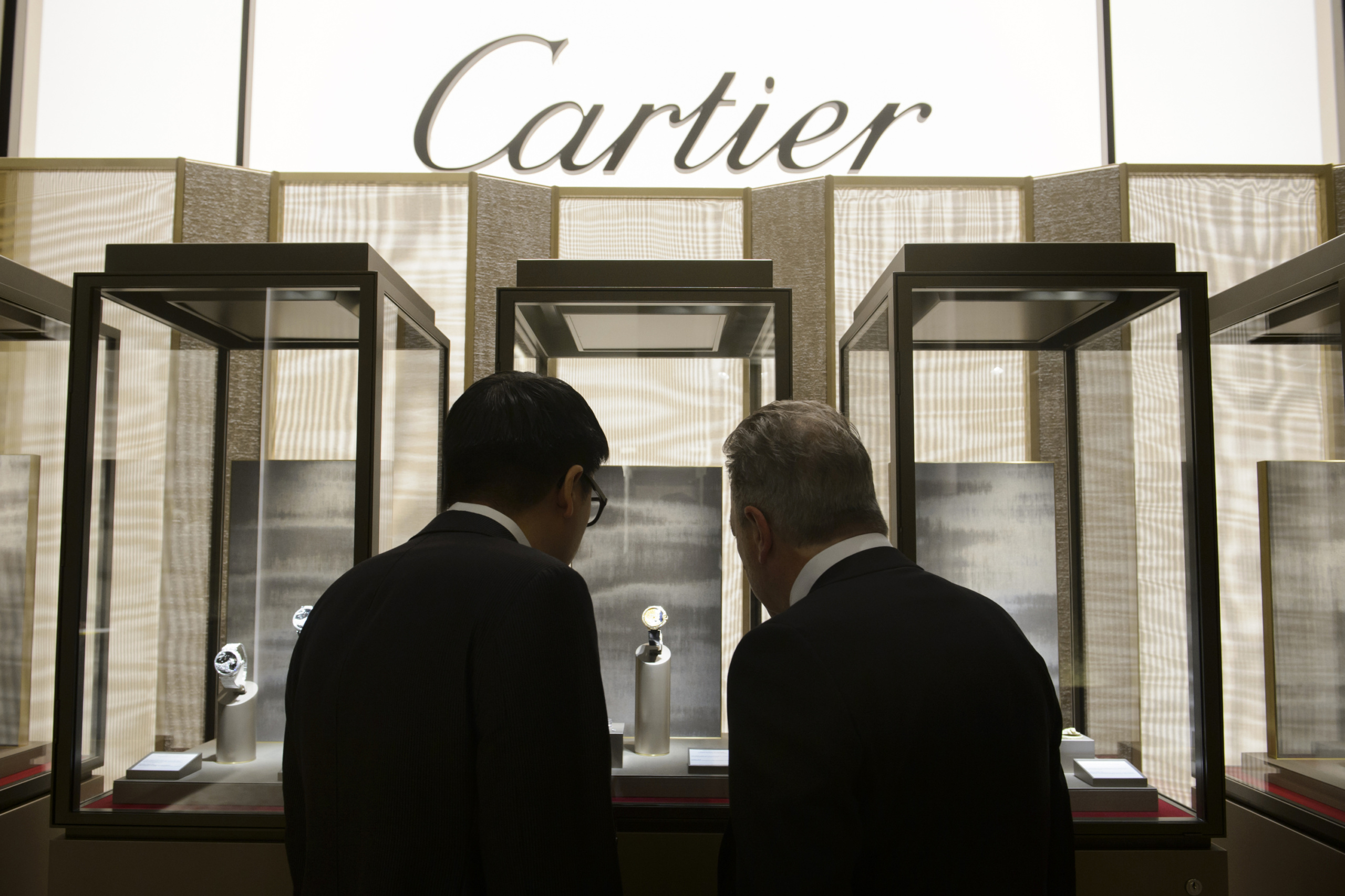 Visitors looks at the stand of Cartier, owned by the Swiss luxury goods group Richemont, during the opening day of the 'Salon International de la Haute Horlogerie' (SIHH), a professional fair in fine watchmaking in Geneva, on January 18, 2016. / AFP / Richard Juilliart (Photo credit should read RICHARD JUILLIART/AFP/Getty Images)