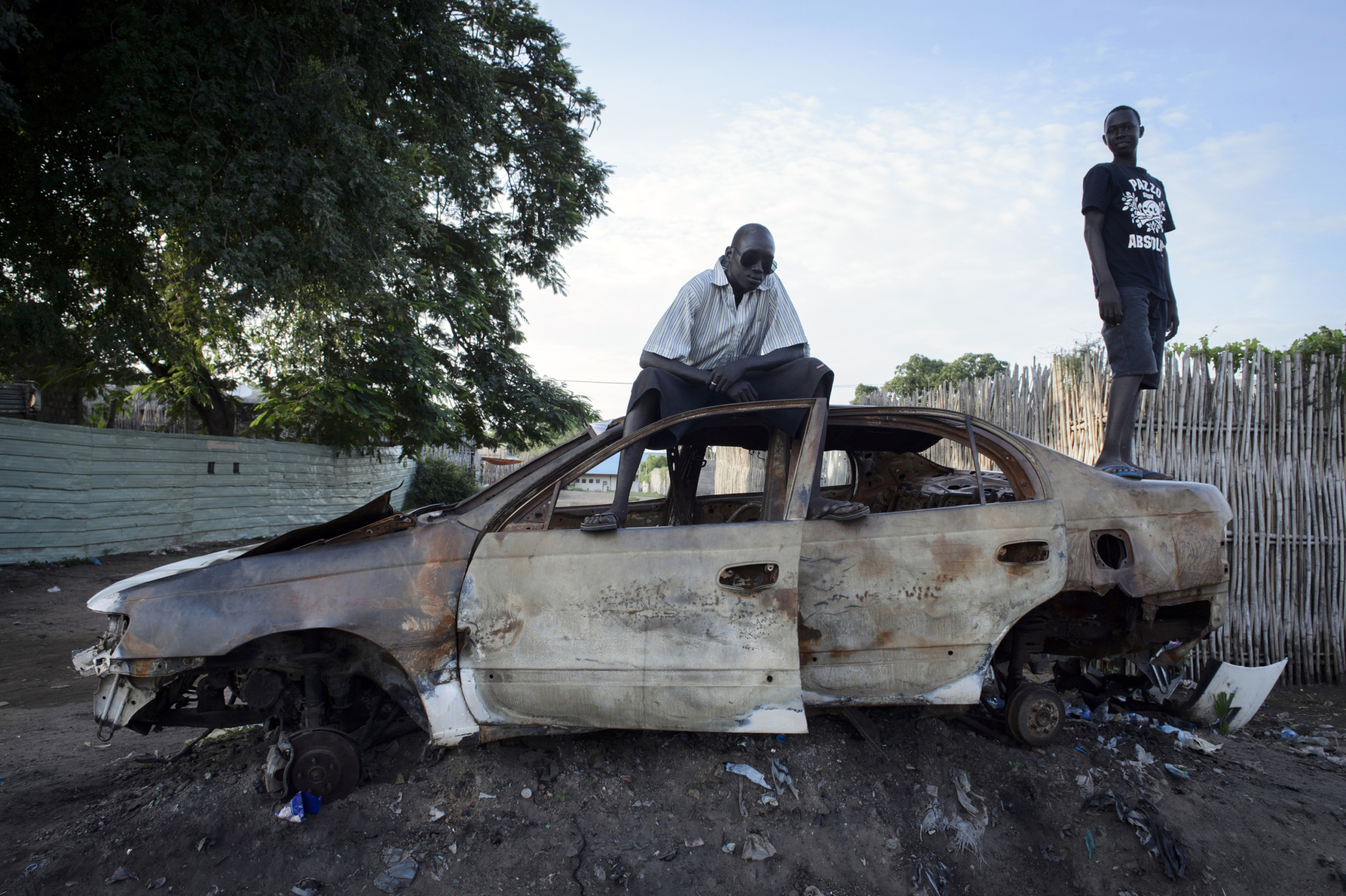 — SOUTH SUDAN
Juba, South Sudan.
Men posing on a destroy car.
On 9th of July 2011 a new country will be born in Africa. The Republic of South Sudan will be the 54th African state and the 193rd nation in the world. But South Sudan is a very poor country, despite its large oil reserves, which account for 98 percent of its income.
South Sudan’s society is deeply divided along tribal lines. The main clan is the Dinka, a pastoral semi-nomadic population. Violence is endemic to the region, often as a consequences of cattle ownership issues. But violence is also very much fed by the uncountable number of weapons circulating in the country, the heavy legacy of a 30 year long civil war against North Sudan.