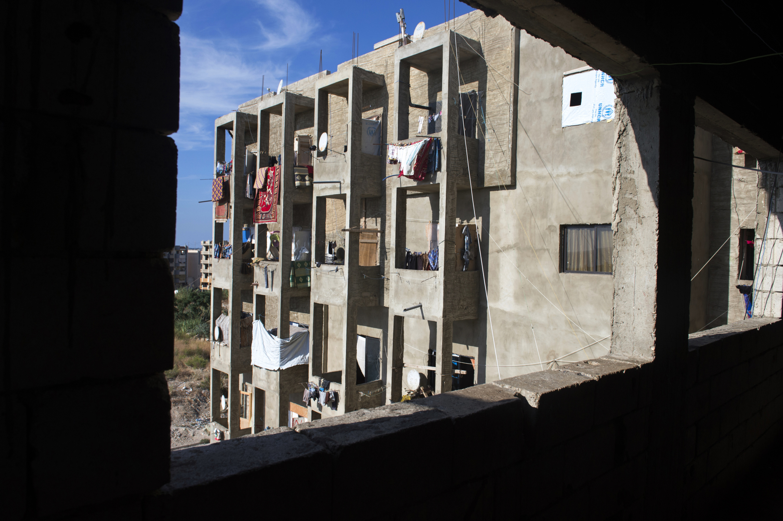 Saida-Lebanon.
An abandoned construction site occupied by Syrian refugees. This building, referred to as a “collective shelter”, is owned by the Islamic University and financed by a Kuwaiti association. About 150 families live within it, all from the Syrian Daraa region. The refugees try to survive through public subsidies and underpaid labor.
the Lebanese government will not allow traditional refugee camps in Lebanon, refugees are finding unusual places to live across the country, including unfinished homes, abandoned shopping malls and schools …….