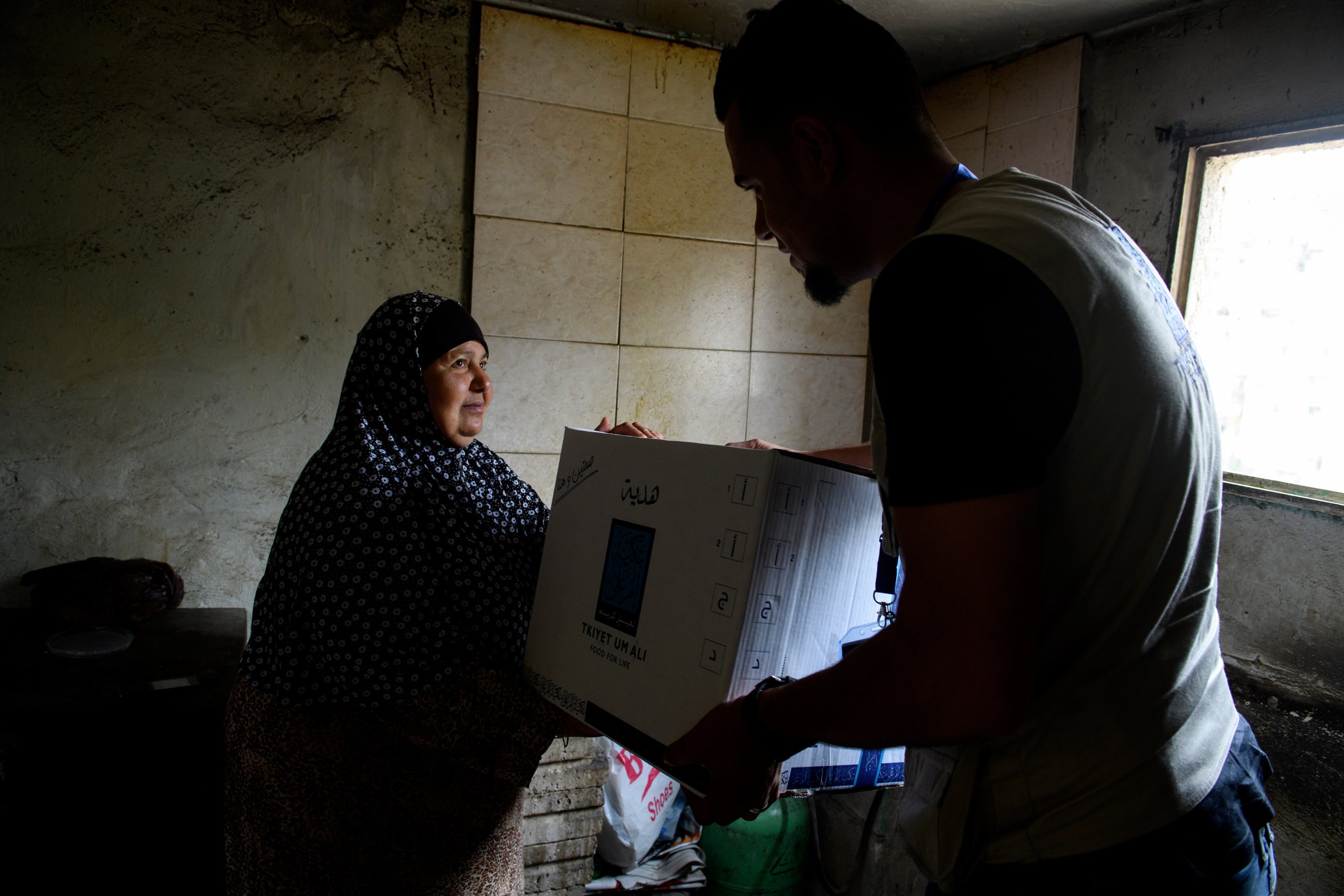 A old man and his wife receiving food parcels from TUA. For this couple without children, having no family and income the only way to be able to eat is to receive the help of this NGO.
A food parcel will be delivered to an endorsed family according to the value of the parcel which in return depends on the number of family members. The food Parcel contains 22 food commodities enough to prepare three meals to the family throughout the month. Currently 30,000 families receive food parcels on monthly basis.
Tkiyet Um Ali (TUA) was founded in 2003 by Her Royal Highness Princess Haya Bint Al-Hussein to represent the first non-governmental organization that seeks to eradicate hunger by providing sustainable food aid through distributing food parcels and serving hot meals at its premises to JordanÕs most unprivileged. Originally conceptualized by Her Late Majesty Queen Alia more than 40 years ago, TUA is inspired by the Islamic concept of providing food for the underprivileged and assuming social responsibility for them. Through this project, Her Royal Highness Princess Haya Bint Al-Hussein continues her motherÕs short lived, yet rich legacy.